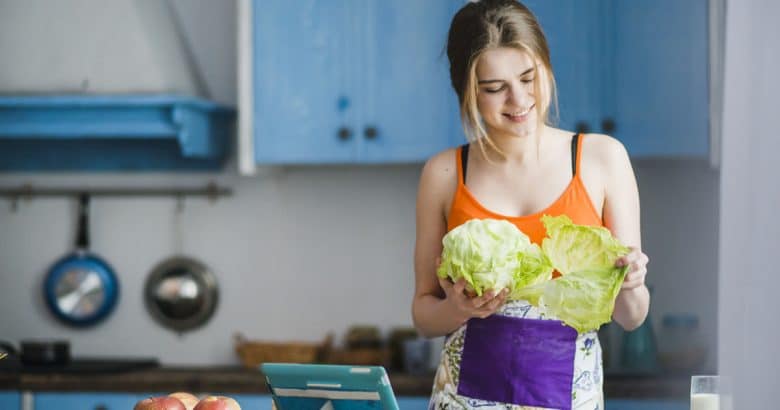 dieta vegana - mulher sorridente com repolho